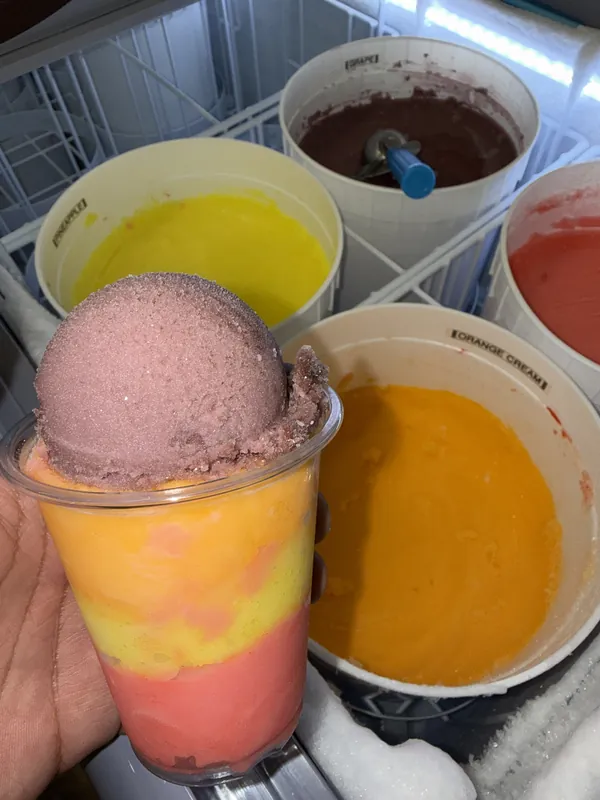 Pink scoop over orange and yellow layers